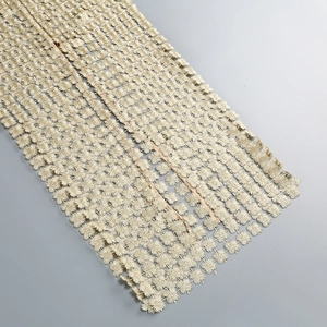 Detailed close-up of light gold floral embroidery lace fabric with intricate mesh patterns