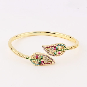 Detailed macro shot of leaf-shaped gold bracelet featuring vibrant multi-color zircon stones
