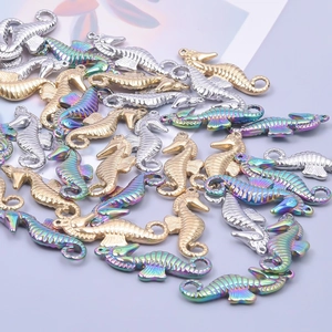Macro detail of seahorse pendants in gold, silver, and rainbow steel for DIY jewelry