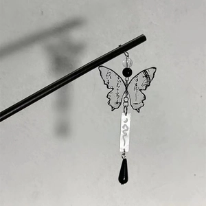 Macro detail of wooden hair pin with calligraphic butterfly pendant and bead