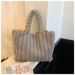 Detail shot of the vertical plush texture and rounded handle of the grey faux fur tote bag