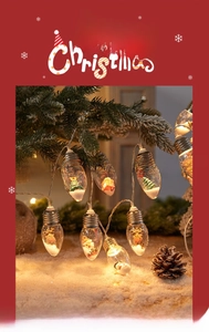Close-up of LED Christmas light bulbs featuring miniature reindeer and warm glowing scenery