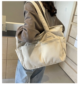 Vue détaillée du sac cabas en velours côtelé blanc crème avec texture et poches externes