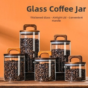 Detail of multi-size glass canisters with wooden U-shaped handles and airtight lids