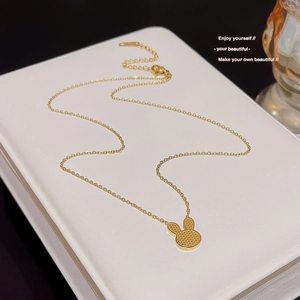 Detail of 18K gold titanium steel necklace featuring a rabbit pendant and pearl accents