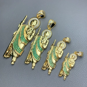 Detailed view of four gold St. Jude pendants with green cubic zirconia in various sizes.