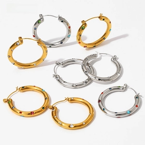 Macro shot of colorful rhinestone inlay on gold and silver stainless steel hoop earrings