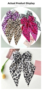 Detail view of large leopard print bow hair clip with silky ribbons in multiple colors