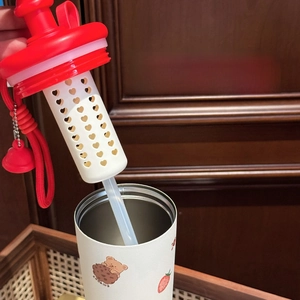 Close-up of the heart-shaped filter tea strainer inside a cute cartoon stainless cup