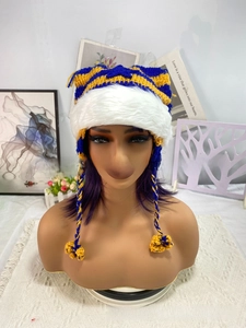 Detail of blue and yellow striped knitted cat ear hat with white faux fur trim and braids