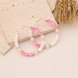 Detail of bohemian hoop earrings with pink clay beads, white pearls and gold accents