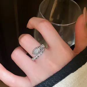 Snake-shaped silver open ring with zircon micro-paving on a model hand with luxury feel