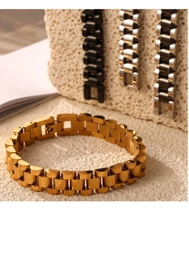 Detail of titanium steel watch-style bracelets with gold finish and foldover clasp