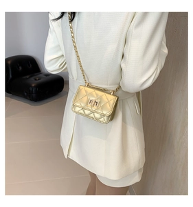Close-up of a mini quilted chain bag in bright gold finish with metal turn-lock detail
