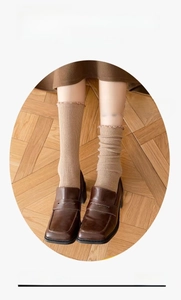 Close-up of brown ribbed knit socks shown in both straight and slouchy wearing styles