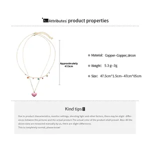 Detail view of gold layered necklace with pink heart pendant and colorful zircon stones