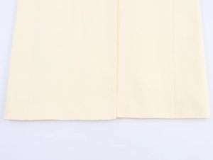 Detailed close-up of premium beige woven fabric and neat stitching on long blazer