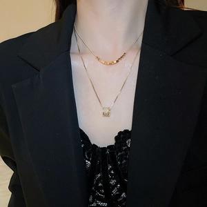 Detail of 18k gold plated double layer necklace with cubic zirconia pendant on neck