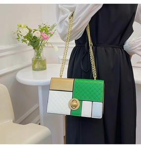 Detail of color-block chain bag with gold lock and quilted pattern on shoulder strap