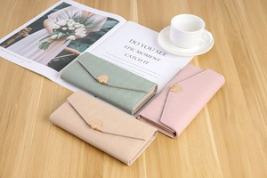 Three-fold printed long wallets in green, pink, and beige with quilted pattern and gold buckles