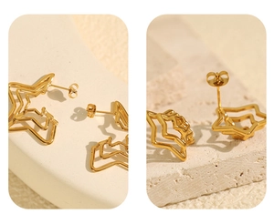 Detail view of gold pentagram earrings with layered hollow texture and smooth metallic finish