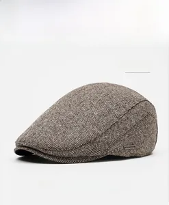 Detailed close-up of khaki beret hat fabric with metal OKSDFOX logo emblem and texture