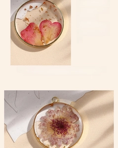 Macro detail of handmade resin charms with dried flowers and gold leaf in copper frames