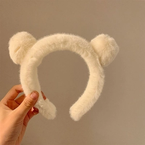 Detail of plush bear ear headband in creamy white fabric for skincare and makeup