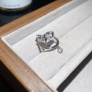 Détail d'une boucle d'oreille étoile en argent et zircone dans son écrin de luxe gris et bois
