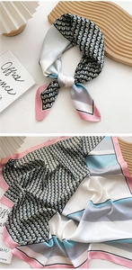 Detail of geometric pattern silk scarf with pastel color blocks and black triangles