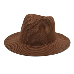 Detail of dark brown straw fedora showing fine woven texture and classic dented crown