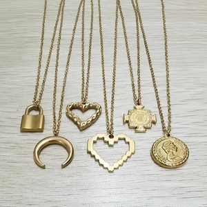Détail de six pendentifs plaqués or avec lune, cœur et pièce sur des chaînes tissées