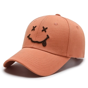 Orange cotton baseball cap featuring a brown embroidered X-eye smiley face pattern
