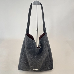 Dettaglio borsa tote in feltro grigio scuro con motivi a stelle e tracolla larga