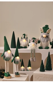 Macro shot of green Christmas gnomes with warm LED glowing noses on display stands