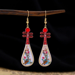 Detailed view of red and white lute-shaped earrings with floral patterns and gold hooks