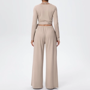 Détail du lien noué au dos du haut court beige à manches longues et du pantalon
