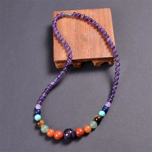 Macro detail of Bohemian 7 chakra stone necklace with 6mm purple beads and silver clasp