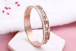Macro view of rose gold stainless steel bracelet with zircons and Greek key pattern