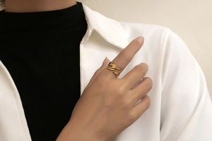 Detail of a minimalist gold lightning bolt ring worn on finger in a lifestyle setting