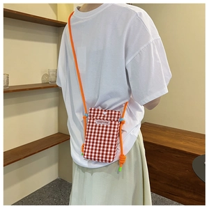 Detail of red and white checkered crossbody phone bag with orange rope strap