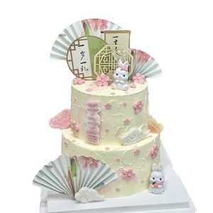 Chinese style cream birthday cake decorated with white rabbit icons and mini fans