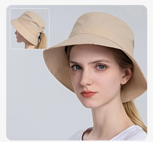 Detail of beige sun hat featuring a ponytail hole design and wide protective brim