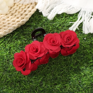 Elegant red flocked rose hair claw clip for women, floral hair accessory on green grass