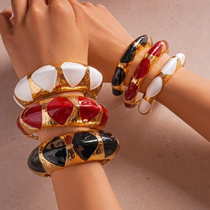 Detailed close-up of retro enamel embossed oval bangles in white, red and black
