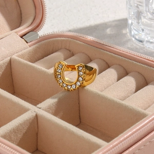 Detailed view of U-shaped gold plated ring with clear cubic zirconia in a jewelry box