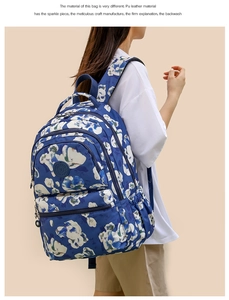 Detail of blue floral PU leather backpack featuring a front logo patch and vintage pattern