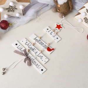 Detail of wooden Christmas tree hanging sign with bells and red star decoration