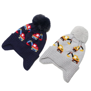 Detail view of children's knit trapper hats with excavator jacquard and pom-poms