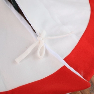 Detailed view of the red and white plush Christmas tree skirt with secure tie-up closure